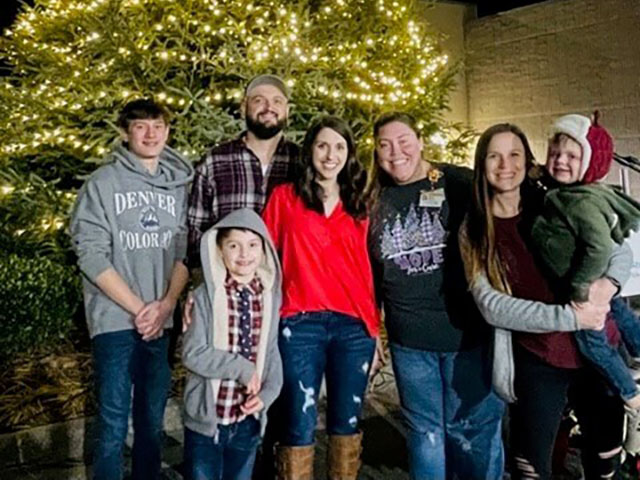 A group of people in casual attire posing for a photo at the Atrium Health Wake Forest Baptist Lexington Medical Center Foundation’s Tree of Love Lighting.