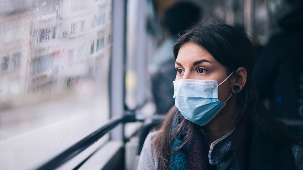 Person with mask on looking out the window. 