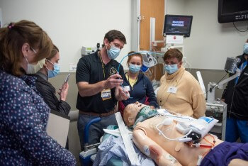 Group of providers practicing on simulation patient.