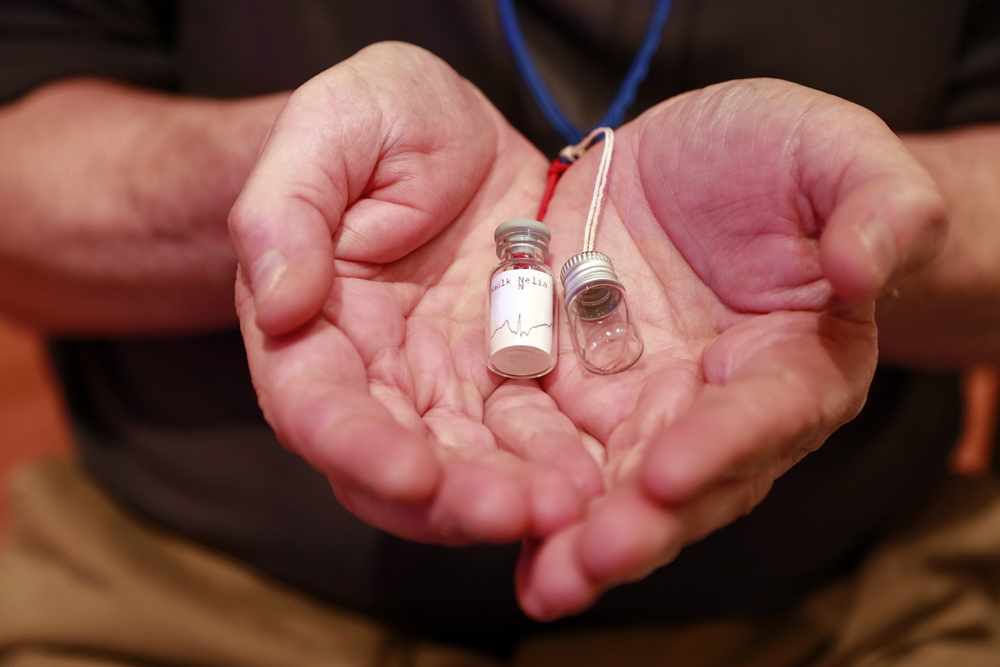 A woman hold a tiny bottle in the palm of her hands.
