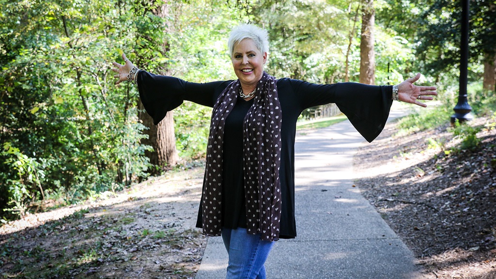 woman standing on wooded path