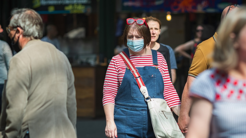 Woman wearing mask in busy outdoor market