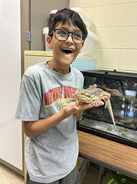 A child holding a reptile.