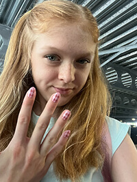 A child showing off their painted nails.