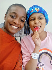 An adult and child smiling at the camera.