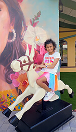 A child sitting on a play horse.