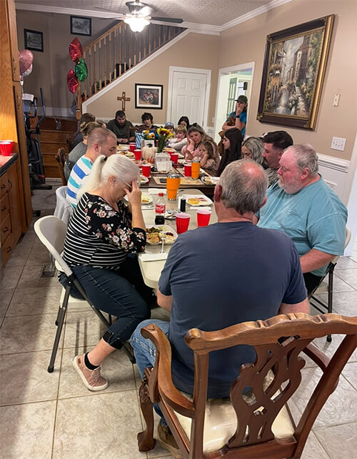 A family sitting at a table for Thanksgiving dinner.