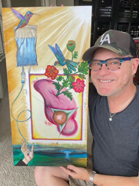 A man holding up a painting.