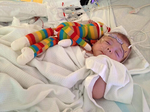 A baby holding a stuffed animal.