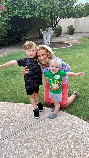 An adult and two children smiling at the camera.