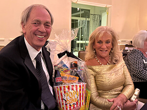 A couple sitting side by side and smiling at the camera.