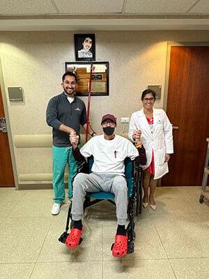 A man sitting in a wheelchair surrounded by medical professionals.