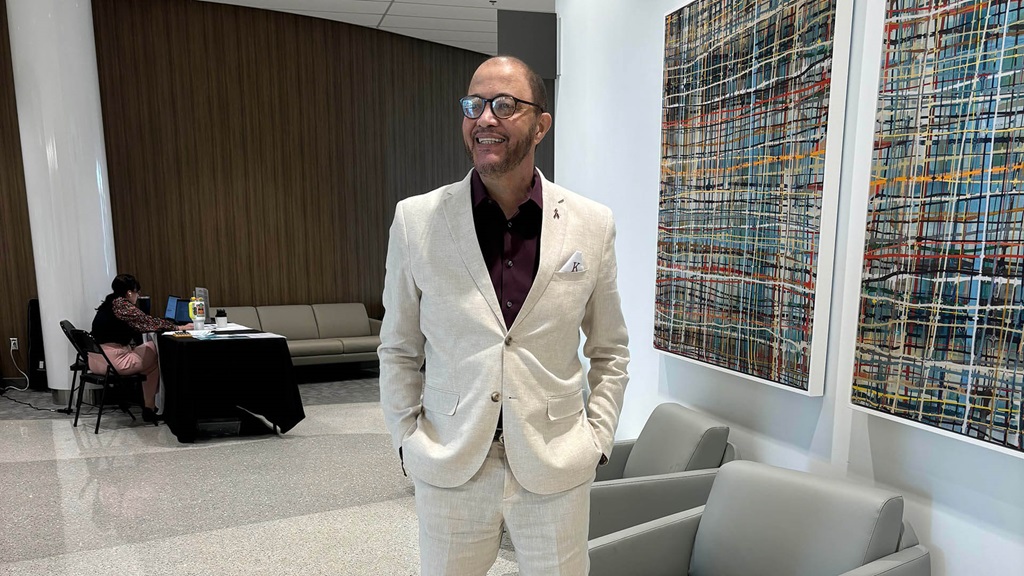 A man wearing a suit and standing in a lobby.