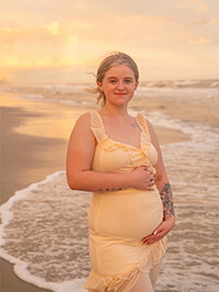 A pregnant women at the beach.