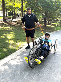Two people training on a bicycle.
