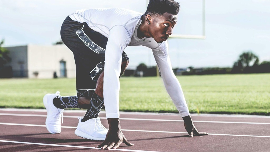 A man getting ready to run at the starting line.