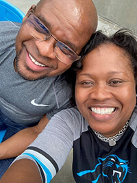 Two people in the stands at a football game.