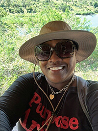 A woman on a safari smiling at the camera.