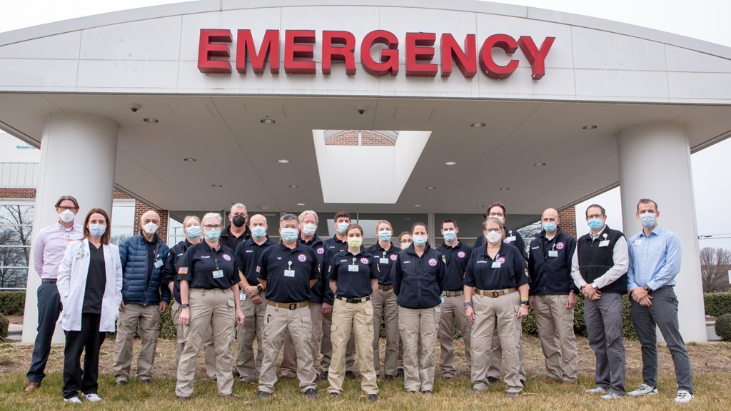 16 medical professionals from The U.S. Department of Health and Human Services National Disaster Medical System (NDMS) standing in front of Atrium Health Pineville