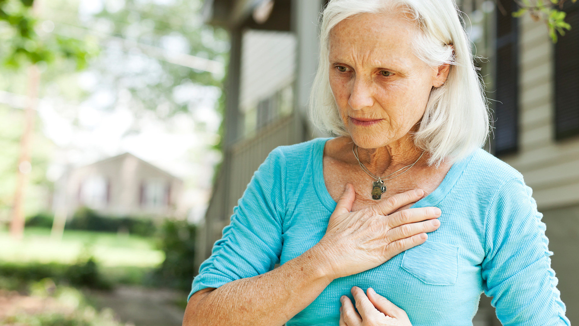 Woman suffering from heart burn holding her chest 