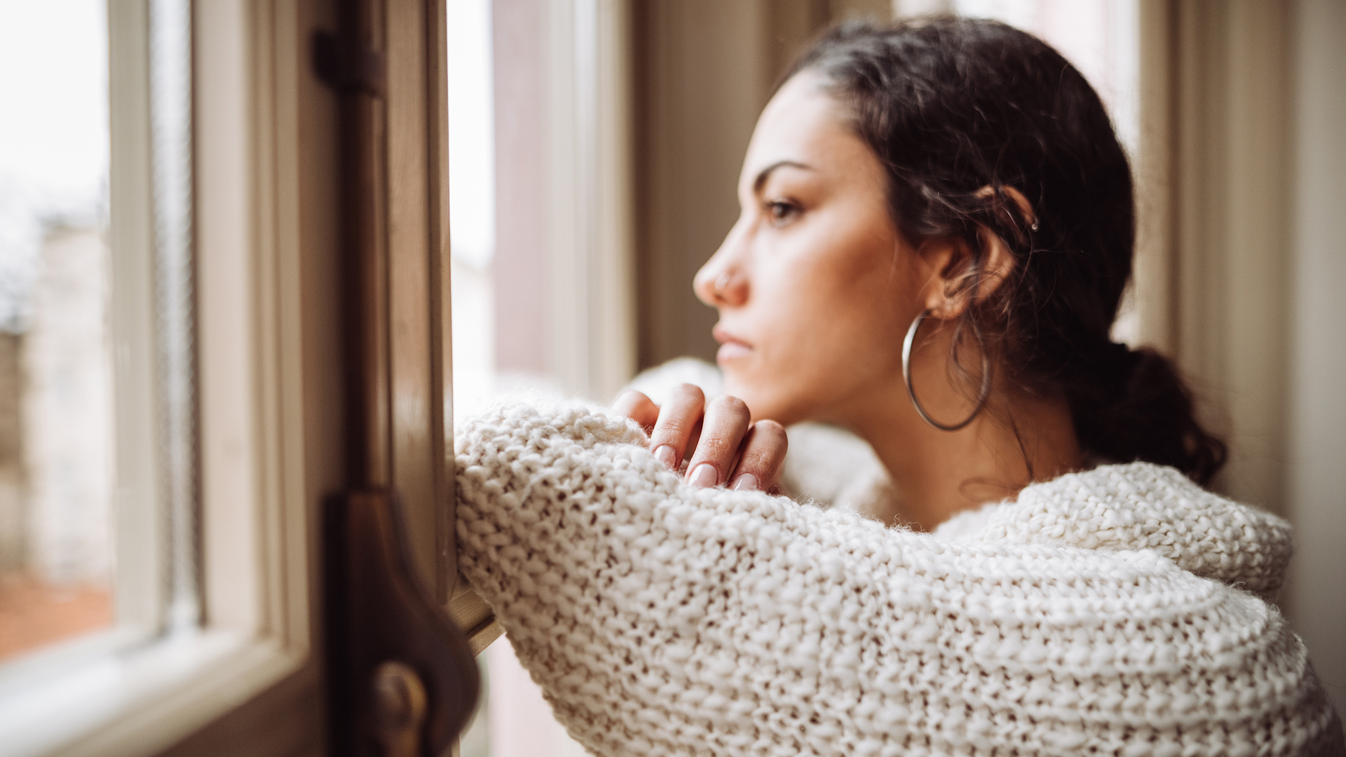 Woman struggling with depression looking out the window