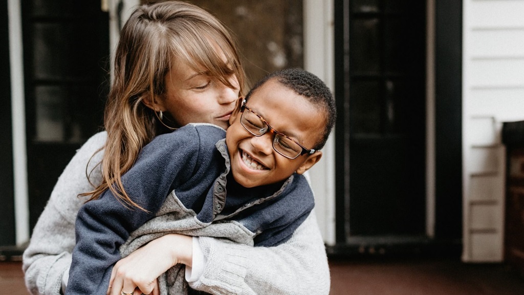 Adult woman hugging male child