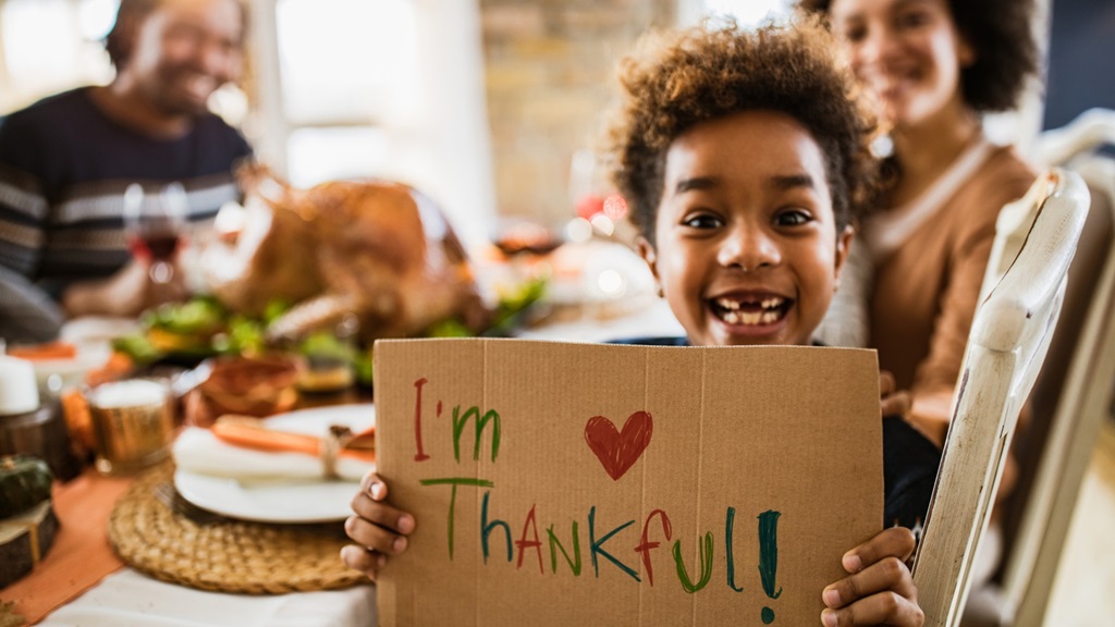 Child holding i'm thankful sign