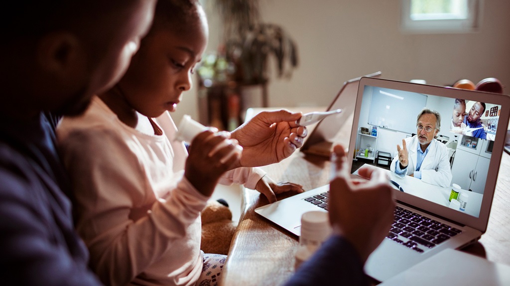 A girl and man participate in a video visit with a healthcare provider