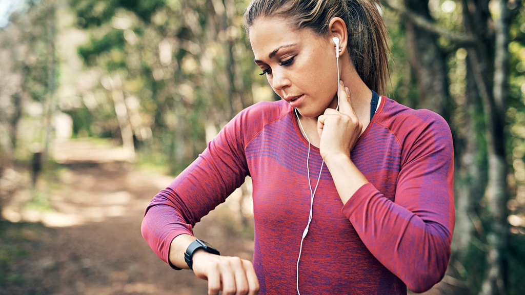 Woman on a run checking her heart rate