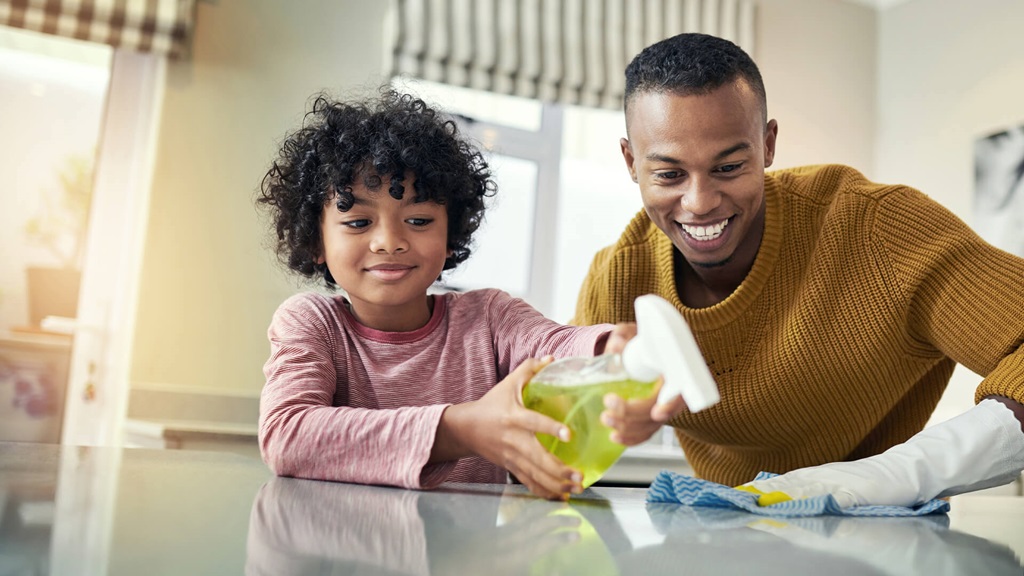 Child and Father Cleaning Countertop