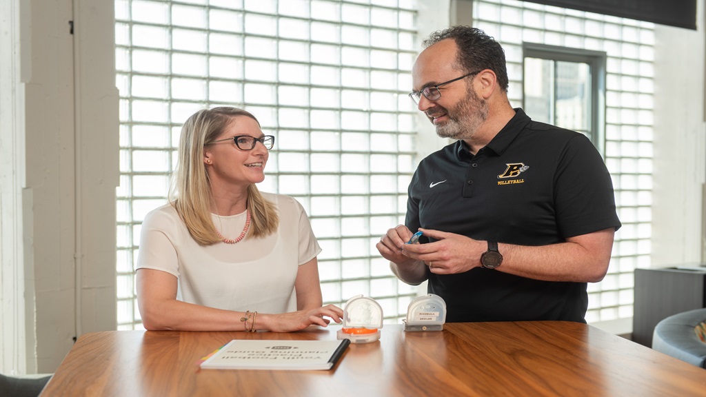 man and woman discussing soccer research