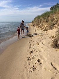Shelby Groot and her children walk on the beach