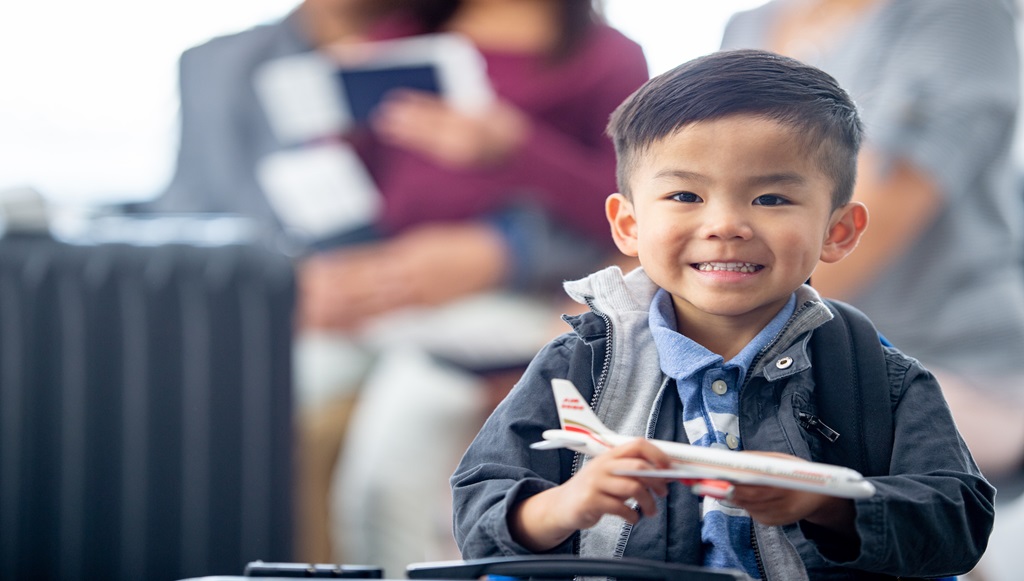 Child holding mini airplane smiling