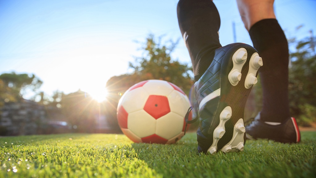 Person playing soccer about to kick the ball