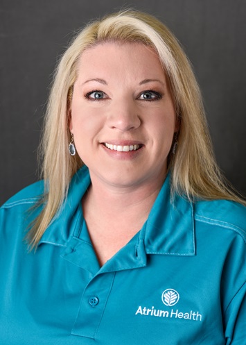 Headshot of a woman smiling at the camera wearing a teal Atrium Health shirt