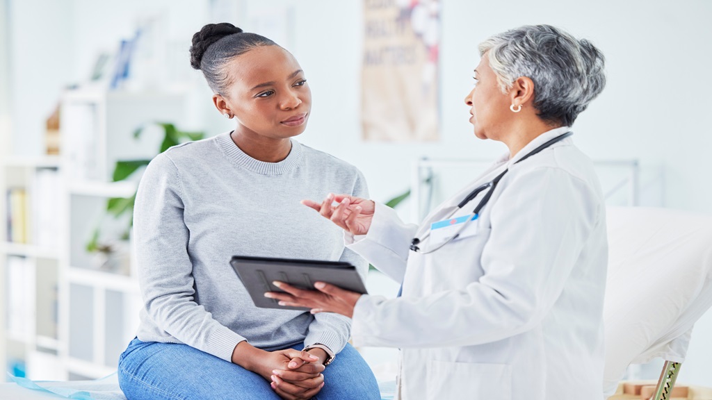 Woman sitting down and listening to doctor 