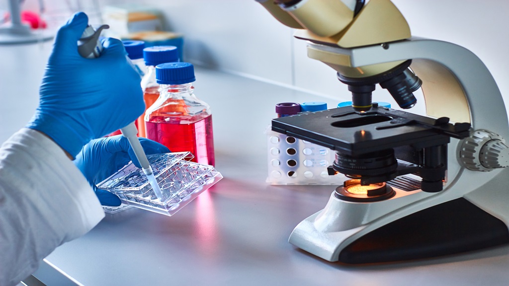 Person with a microscope in a lab