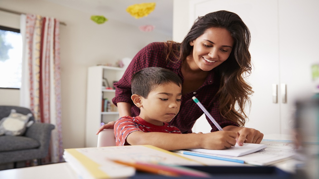 child at table doing homework