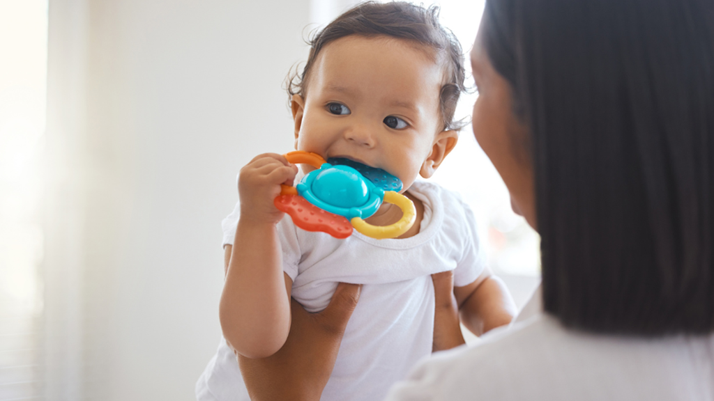 baby holding teething toy