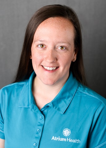 Headshot of a woman smiling at the camera wearing a teal Atrium Health shirt