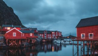 Red houses over water under overcast cloudy sky in Europe.