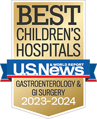 A gold badge with a red and blue ribbon holding the U.S. News and World Report logo recognizing best children's hospitals for gastroenterology and GI surgery.