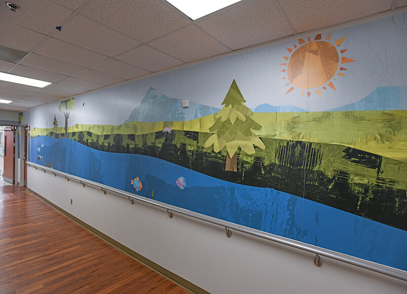 A landscape mural on the wall of a hospital hallway