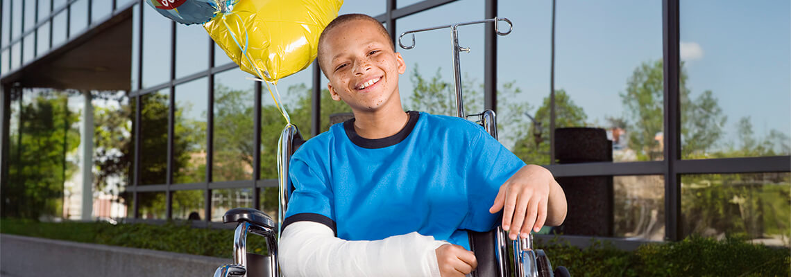 Boy With Broken Arm And Balloons In Wheelchair